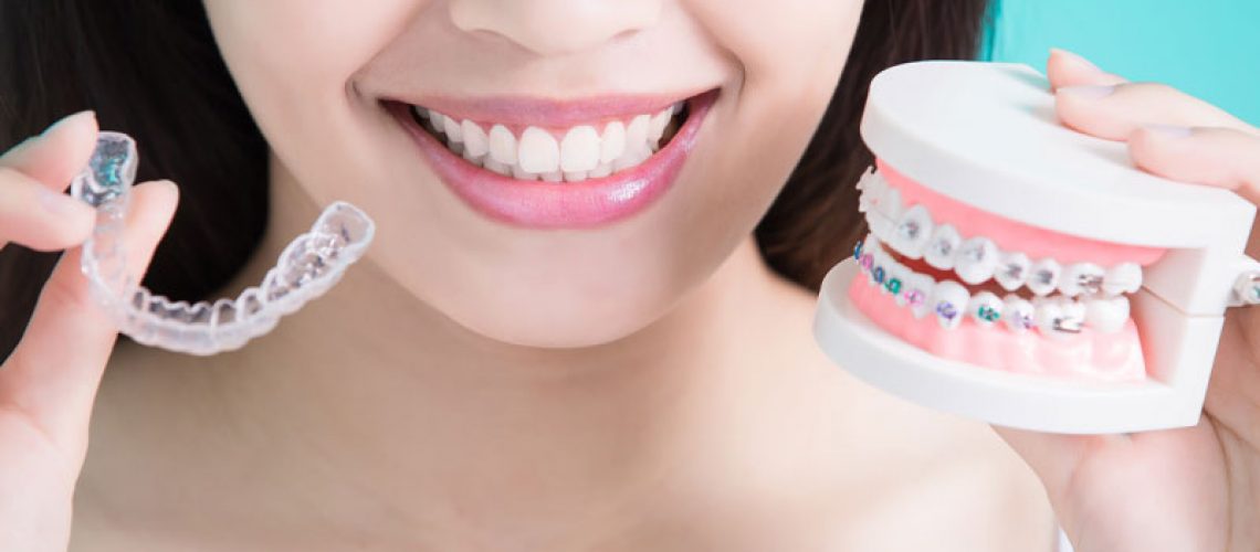 an invisalign patient holding a tray of invisalign